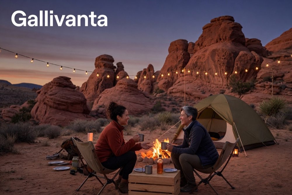 Two solo travelers meeting at a desert campground during a road trip, sharing stories by string lights